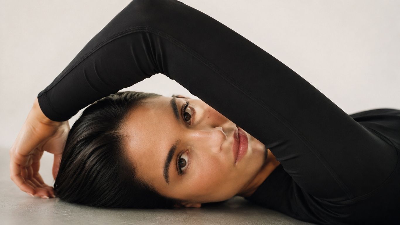 Editorial-Aufnahme einer Frau in ruhiger Pose vor hellem Hintergrund – Kosmetik und Wohlbefinden bei Glamskin.